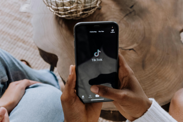 person holding black android smartphone with the tiktok app open on the screen to illustrate adding a link to tiktok bio