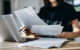 Cropped shot of young Asian woman handling personal banking and finance with laptop at home