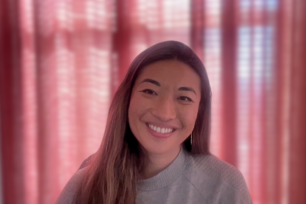 The COO of Bluesky, Rose Wang, sits in her home office with a pink curtain backdrop