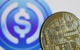 Representation of cryptocurrency and USD Coin logo displayed on a screen in the background are seen in this illustration photo taken in Krakow, Poland on June 10, 2022.