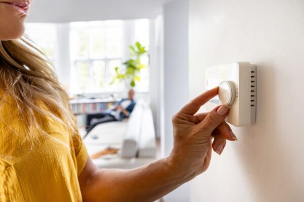 Person turning a thermostat