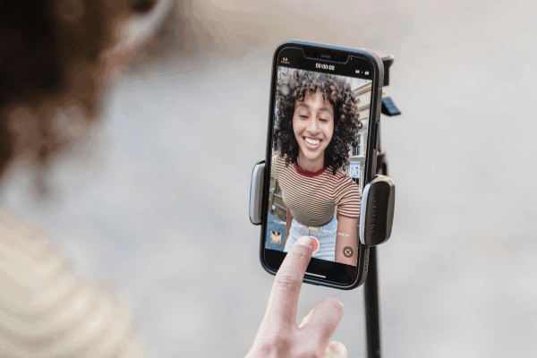 woman recording a video on her phone in selfie mode, to illustrate filming an unlockable reel on Instagram